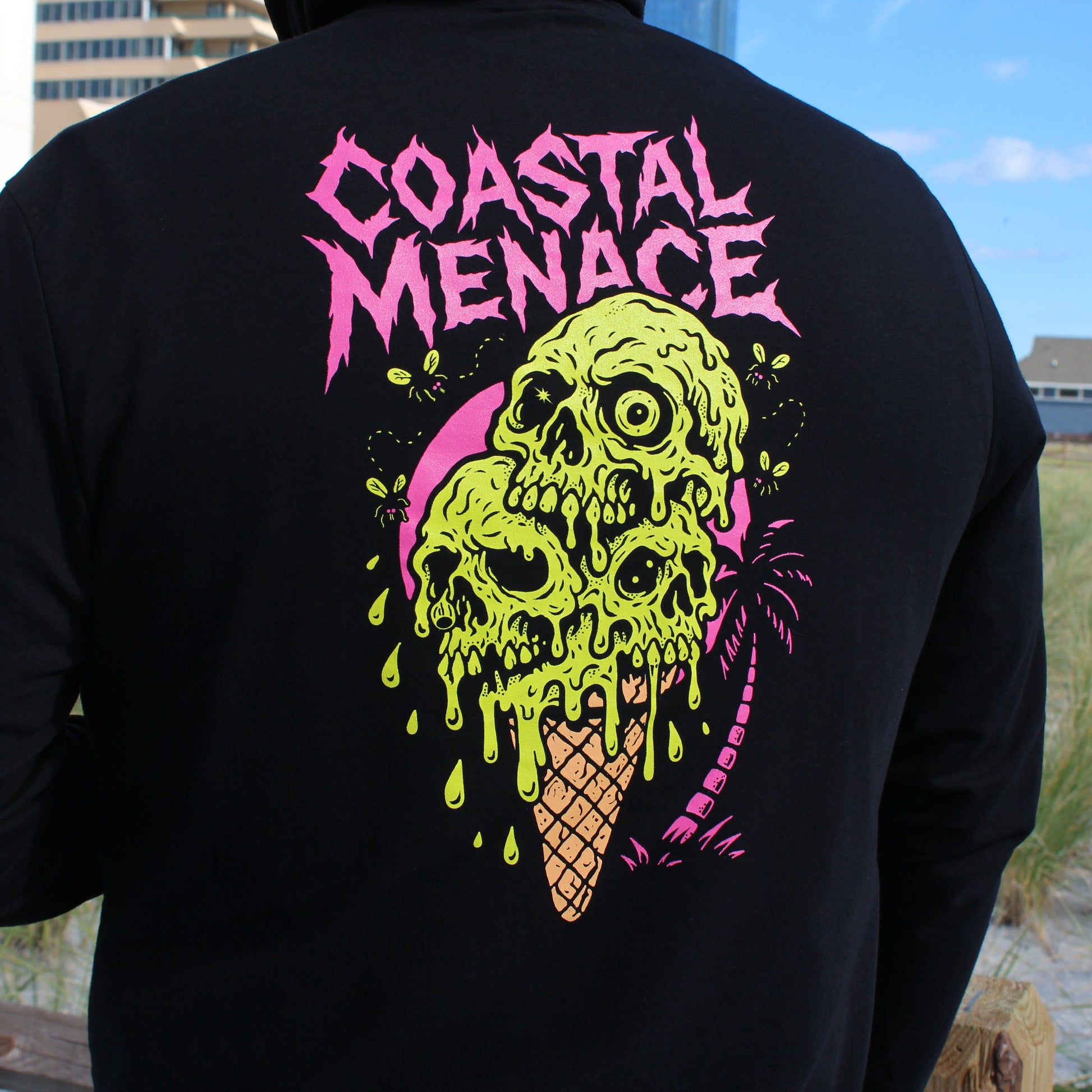 Black sweatshirt with 'Coastal Menace' design featuring a skull ice cream cone on a beach.
