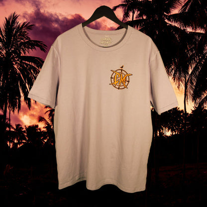 Light purple t-shirt with a logo  against a palm tree sunset background