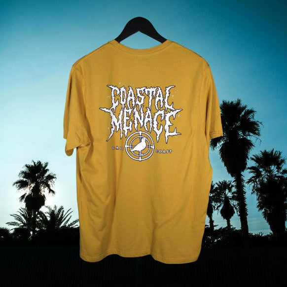 Yellow t-shirt with white font 'Coastal Menace' graphic against a blue sky and palm trees background