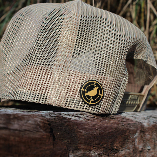 Khaki mesh cap with a logo on a wooden surface with a natural background
