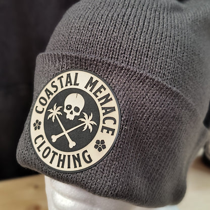 Closeup of grey pom beanie showing round patch detail