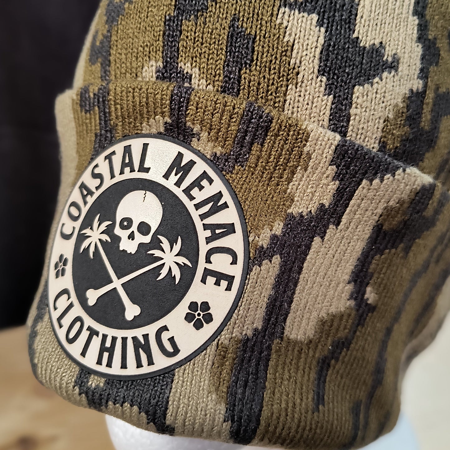 Closeup of camo Base Threat beanie and patch