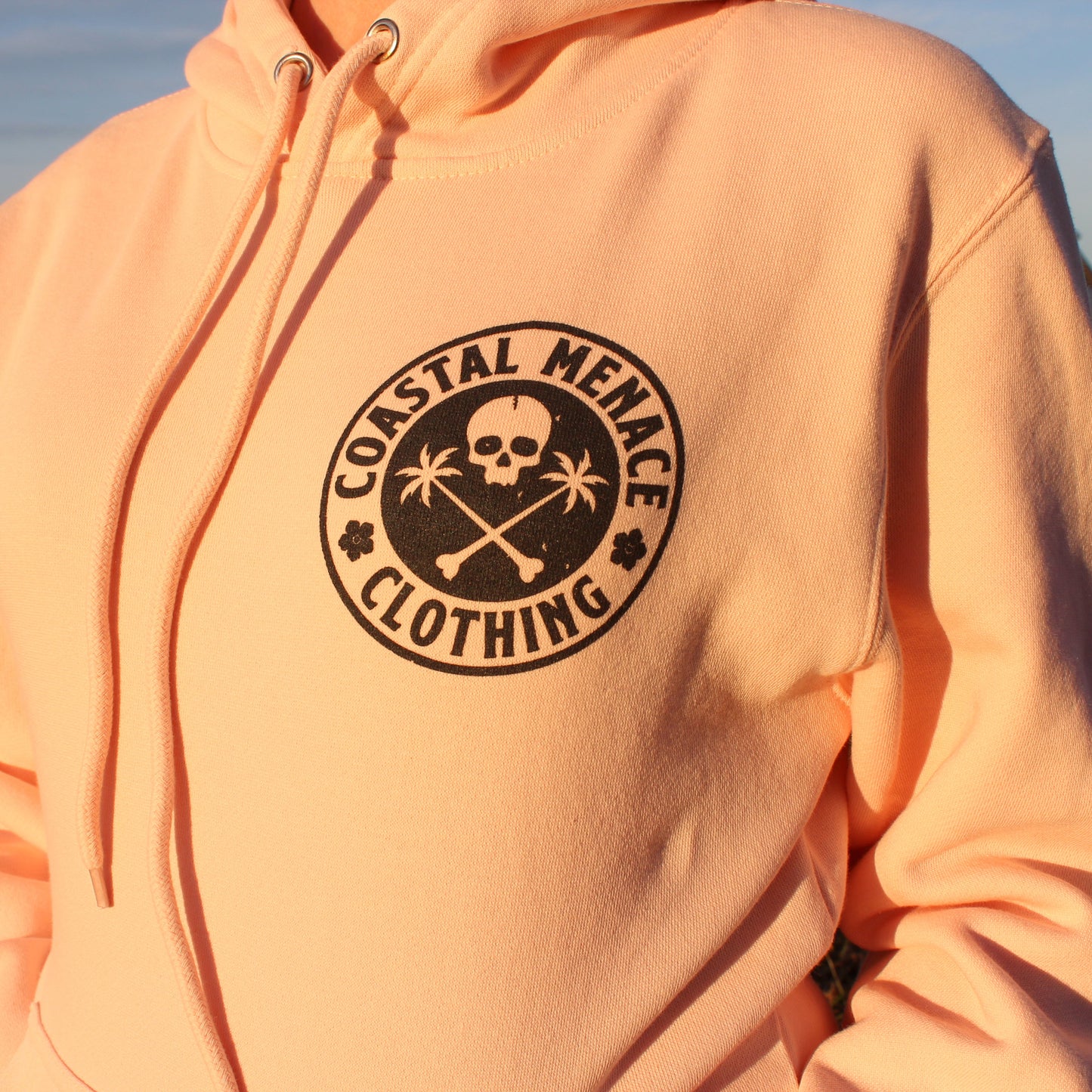 Detailed close-up of the Base Threat pink hoodie front chest print.