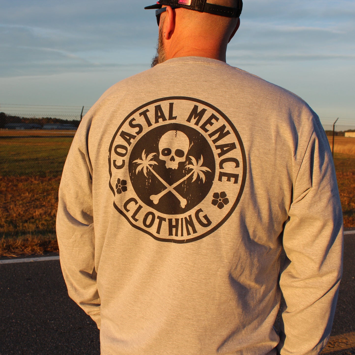 Close-up of the Base Threat heather gray long sleeve tee back print with skull and palm trees.