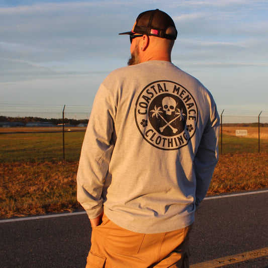 Back view of the Coastal Menace Base Threat heather gray long sleeve tee while walking on a road at sunset.