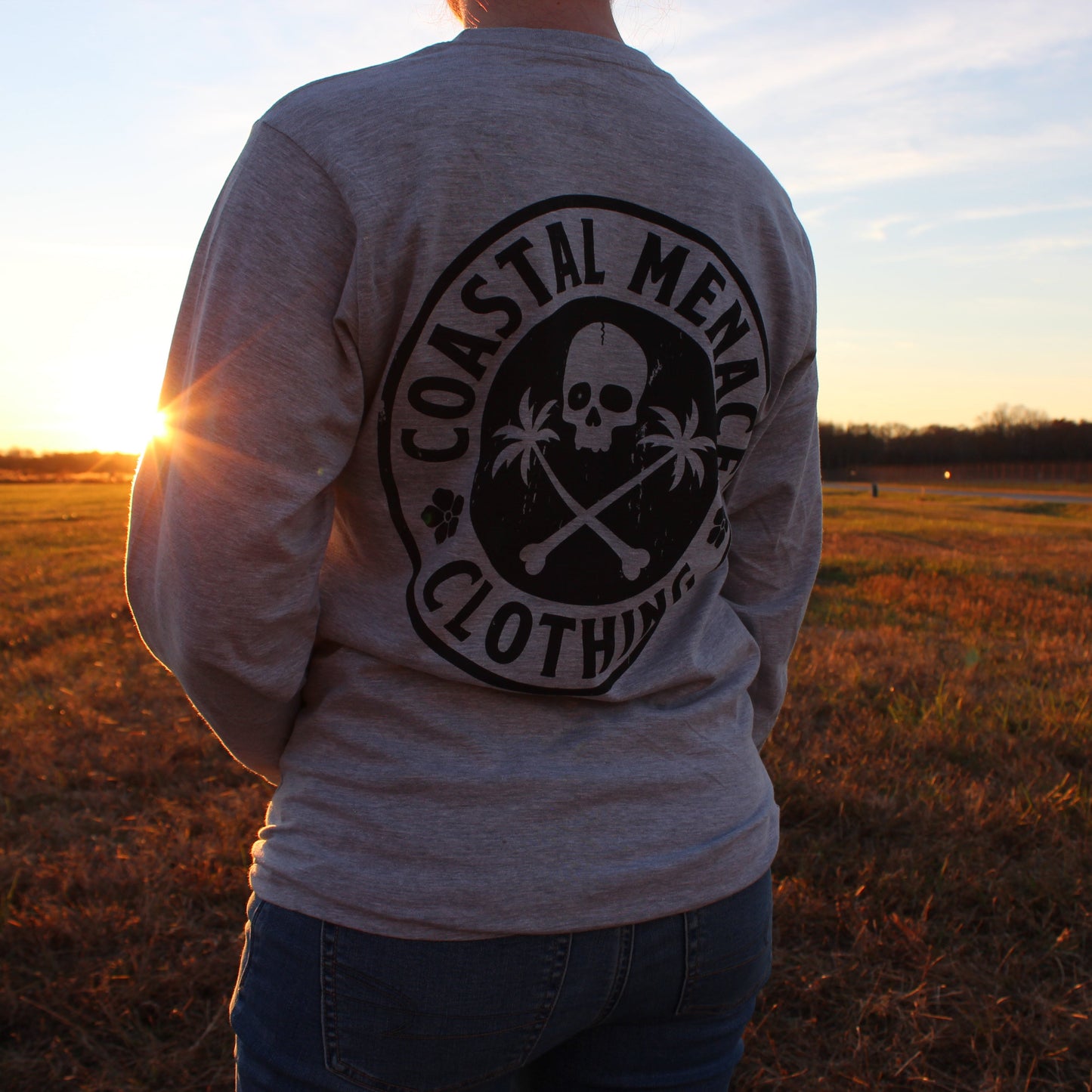 Back view of the Base Threat heather gray long sleeve tee at sunset.