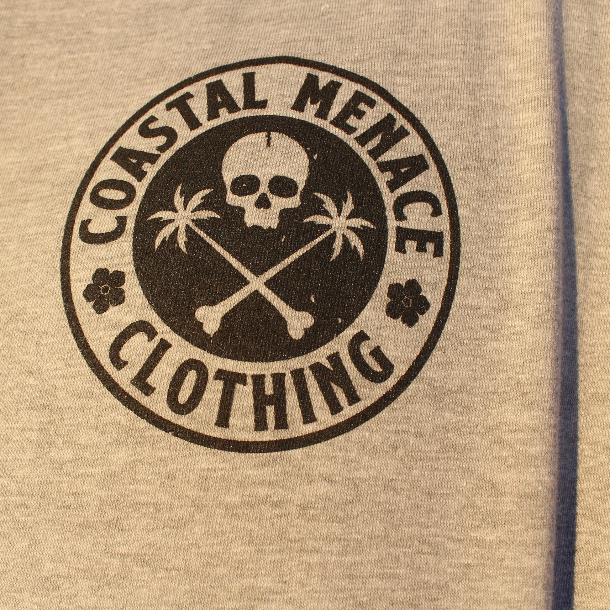 Detailed close-up of the Base Threat heather gray long sleeve chest logo.
