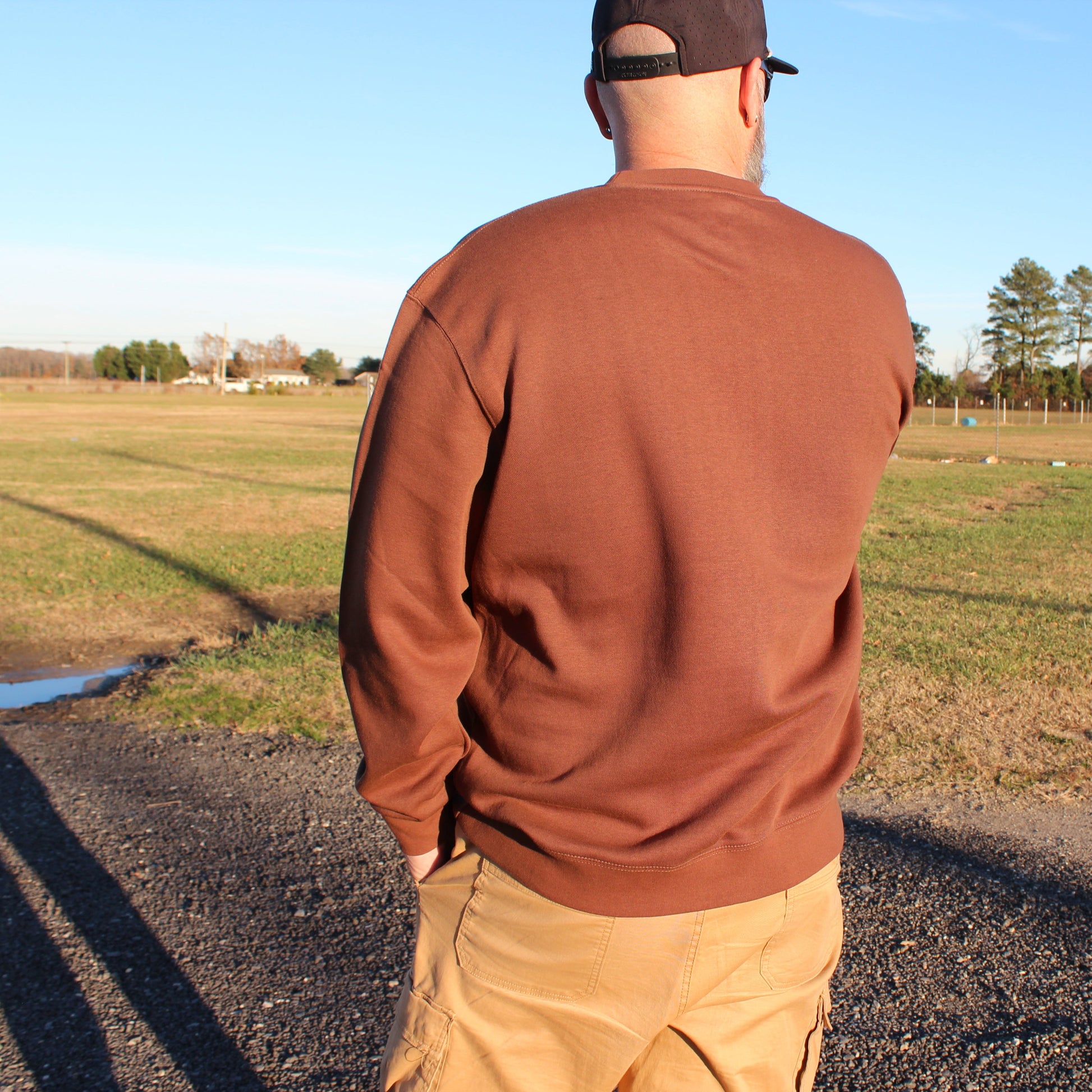 man wearing coastal menace retro script crewneck showing back